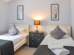 CroptonにあるBrewers Cottageのベッドルーム1室(ベッド2台、ナイトスタンドのランプ付)