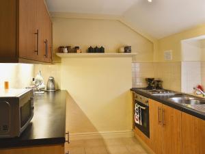 a kitchen with a sink and a microwave at Jug And Glass Cottage in Upper Langwith