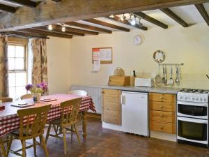 a kitchen and dining room with a table and chairs at The Corn Mill in Branthwaite