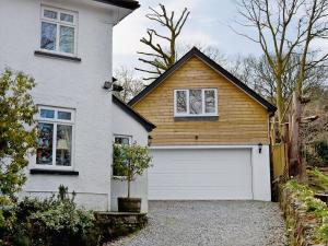 a white house with a white garage door at Magpies Rest in Horrabridge