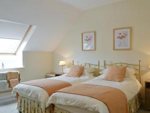 two beds sitting next to each other in a bedroom at The Linhay in East Worlington