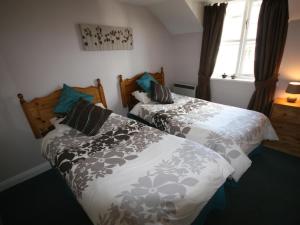 a bedroom with two beds and a window at College Gate in Windermere