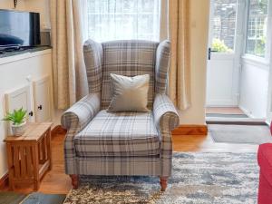 a chair with a pillow in a living room at 1 Tower Cottage in Portinscale