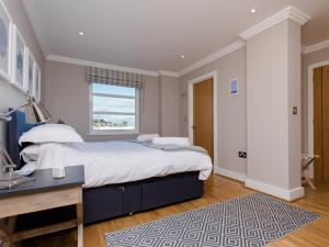 a bedroom with a large bed and a window at 16 Marinus in Cowes