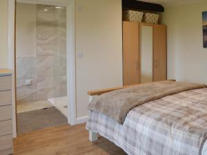 a bedroom with a bed and a walk in shower at Saddlers Cottage in Alkham