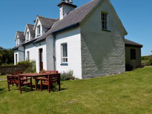 a house with a picnic table in front of it at Olafs Cottage in Garlieston