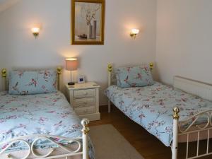 1 dormitorio con 2 camas y mesita de noche en Fawnlea Cottage en Staindrop