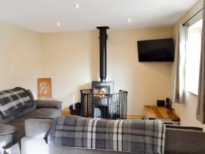 a living room with a couch and a wood stove at Booth Farm Bungalow in Hollinsclough