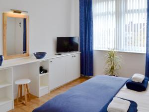 - une chambre avec un lit, une télévision et une fenêtre dans l'établissement Holmlea, à Alnwick