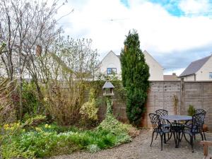 d'une terrasse avec une table et des chaises dans le jardin. dans l'établissement Holmlea, à Alnwick