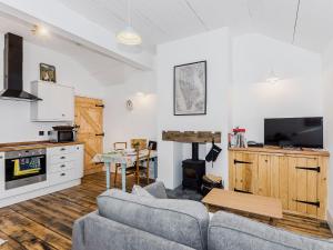 a living room with two couches and a tv and a table at Ty Sam in Llanwnda