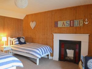 1 dormitorio con 1 cama y chimenea en Sandys Hoose en Portmahomack