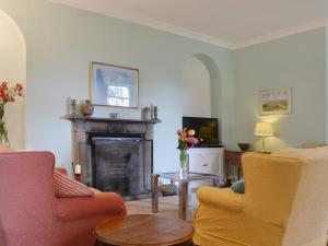 a living room with two chairs and a fireplace at The Court House in Cowan Bridge