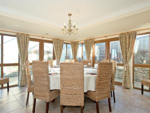 a dining room with a table and chairs and windows at Magnolia Cottage in Aberaeron