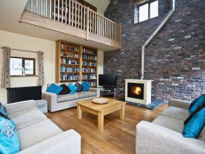 a living room with two couches and a fireplace at The Cowshed in Froghall