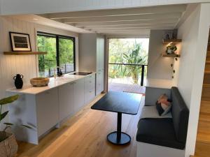 a kitchen with a couch and a table in a room at Hilltop Woods Noosa in Tinbeerwah