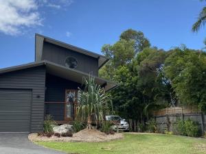 a house with a car parked in front of it at Hilltop Woods Noosa in Tinbeerwah