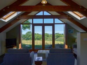 uma sala de estar com uma grande janela e sofás em The Roost em Blisland