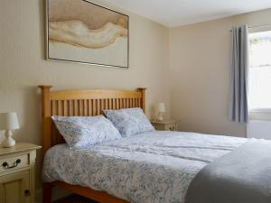 a bedroom with a bed and a picture on the wall at The Coach House in Greenodd