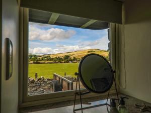 een spiegel in een raam met uitzicht op een veld bij The Wheelhouse in Kirk Yetholm