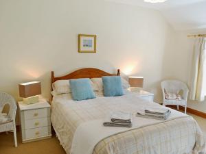 מיטה או מיטות בחדר ב-2 Woodford Cottages