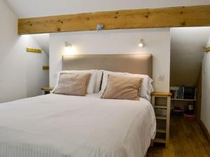 ein Schlafzimmer mit einem großen weißen Bett mit zwei Kissen in der Unterkunft Bryn Gwnog in Capel Garmon