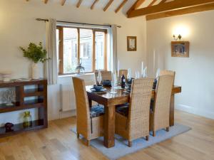 a dining room with a wooden table and chairs at Beech Barn in Horning