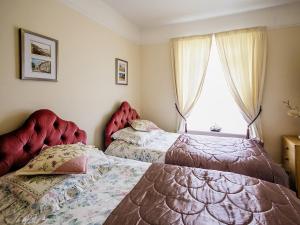 a bedroom with two beds and a window at Half Moon Cottage in Martham