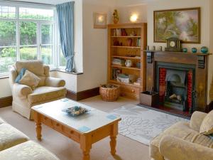 a living room with a couch and a fireplace at Half Moon Cottage in Martham