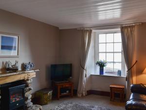 a living room with a fireplace and a television at High Tide in Cellardyke