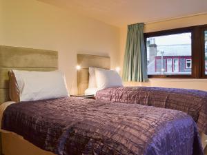 a hotel room with two beds and a window at The Gregorton Coachhouse in Rattray