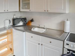 a kitchen counter with a sink and a microwave at Tracara in Horning