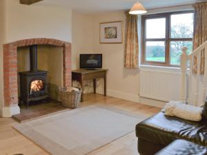 a living room with a fireplace and a couch at Blackthorn Cottage in Norton Disney