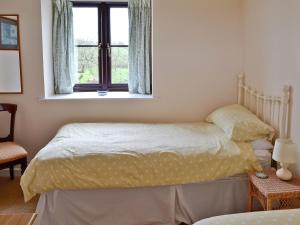 Schlafzimmer mit einem Bett und einem Fenster in der Unterkunft The Old Haybarn in Long Sutton