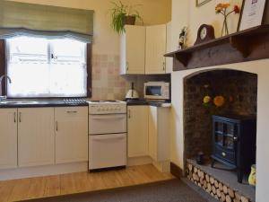 a kitchen with a stove and a fireplace at The Dairy in Burscough