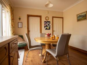 uma cozinha e sala de jantar com mesa e cadeiras em Staffin em Newcastleton