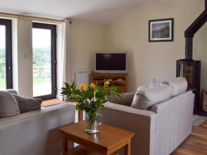 a living room with a couch and a tv at Hoppers Cottage in Ticehurst