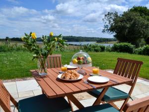 a wooden picnic table with a bowl of fruit and juice at Hoppers Cottage in Ticehurst