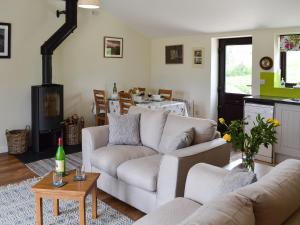 a living room with two couches and a stove at Hoppers Cottage in Ticehurst