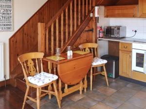a kitchen with a wooden table and two chairs at Elm Barn Lodge in Southampton