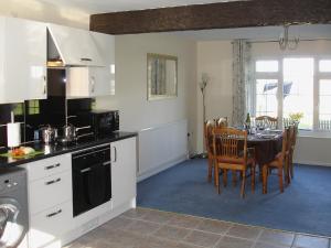 a kitchen and dining room with a table and chairs at Jubilee Cottage in Pyworthy