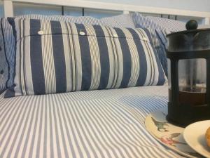 a bed with blue and white striped pillows and a blender at Seaview Cottage - 27991 in Dunure