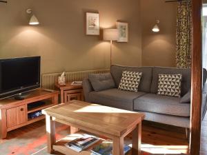 a living room with a couch and a tv at Letterbox Cottage in Far Sawrey