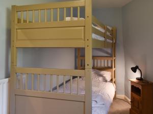 - un lit superposé jaune dans un dortoir avec une échelle dans l'établissement Letterbox Cottage, à Far Sawrey