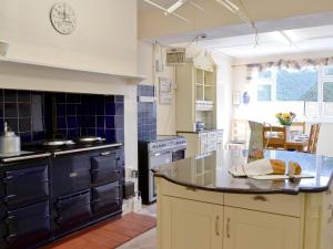 a kitchen with a stove and a counter top at Beaford House in Beaford