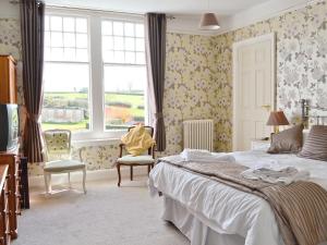 a bedroom with a large bed and a window at Beaford House in Beaford
