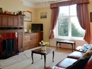 a living room with a couch and a fireplace at Beaford House in Beaford