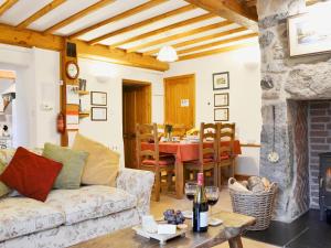 a living room with a couch and a table at Granary Cottage in Saint Twynnells