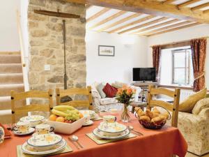 a dining room with a table with fruit on it at Granary Cottage in Saint Twynnells