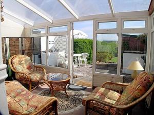 a living room with chairs and a table at Shingle Cottage in Seascale